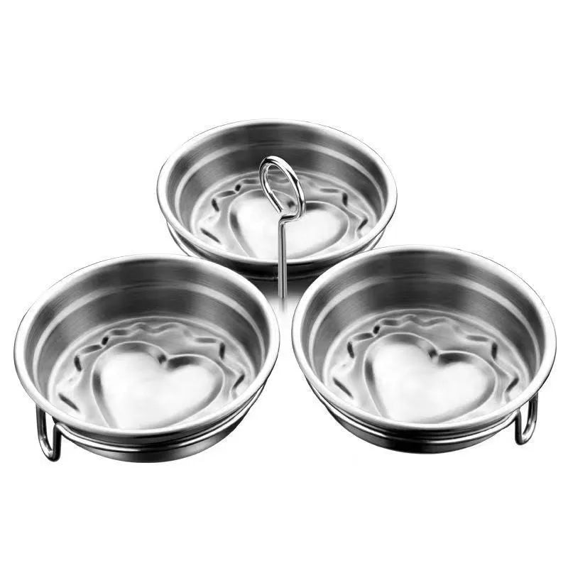 Small stainless steel heart-shaped egg steamer or cooker on a kitchen counter.