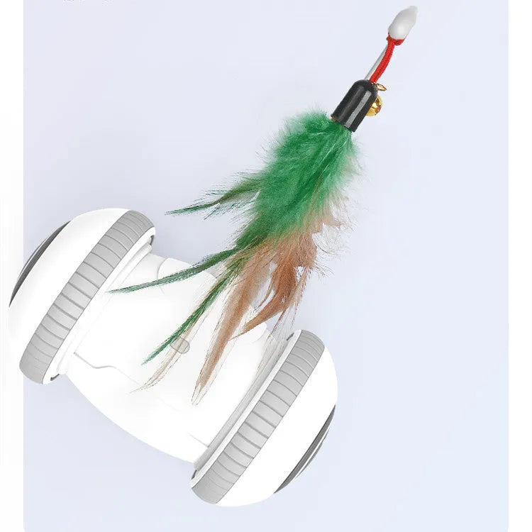 White and grey automatic interactive cat toy with interchangeable feather accessory on a floor, USB cable attached