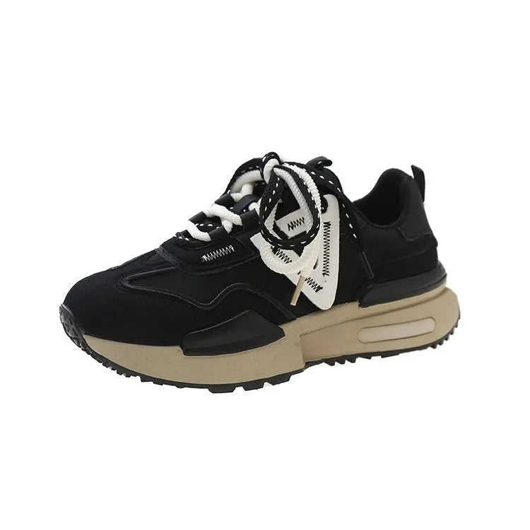 Women's black platform trainers with round toe and lace-up design, showing rubber sole