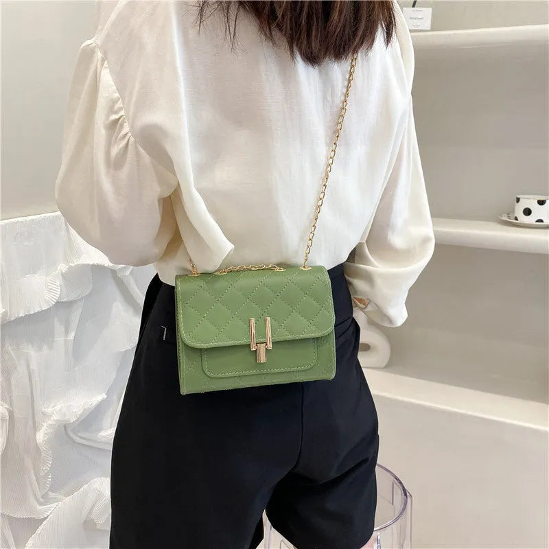 Women's diamond lattice chain crossbody bag in black with adjustable shoulder strap