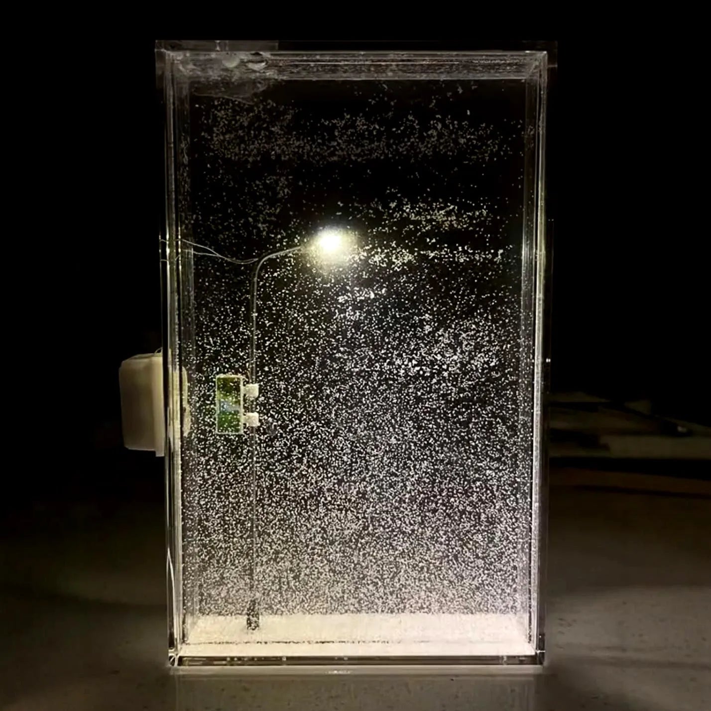 DIY kit components for building a snowy landscape night light with small houses and LED street lights.