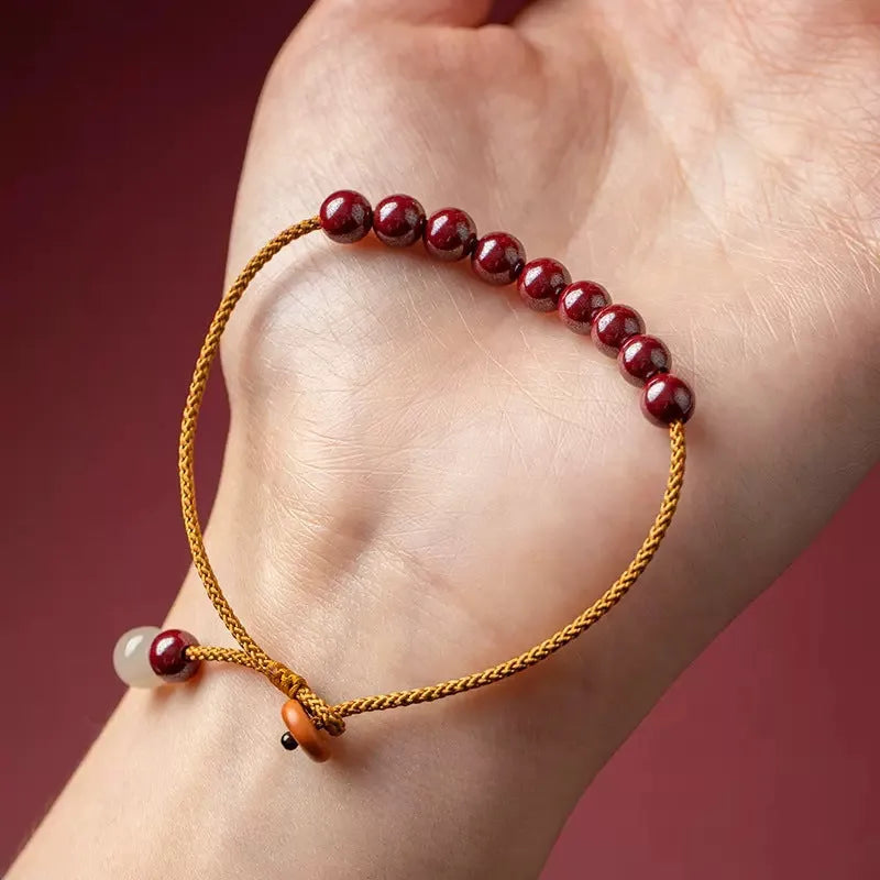 Hand-woven bracelet made from raw cinnabar ore and Hetian jade in a simple geometric shape.