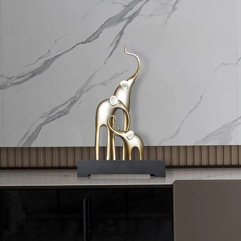 Detailed resin elephant figurine ornament in metallic gold finish on a wooden shelf.