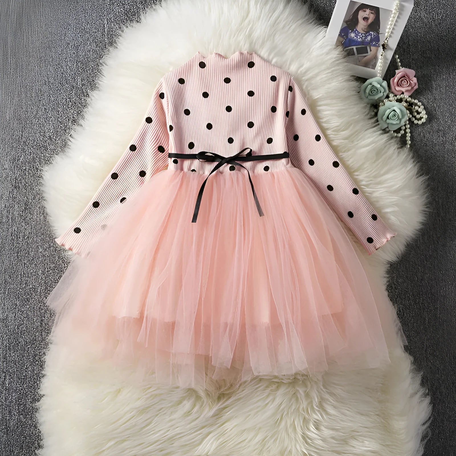 Baby girl in a long sleeve black tutu lace dress for a birthday party or christening