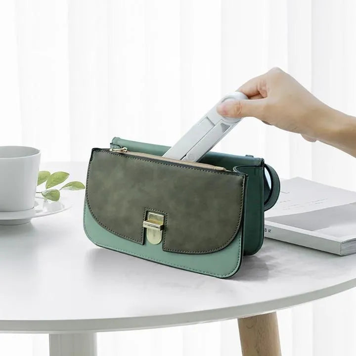 Black foldable aluminium tablet holder open in landscape mode supporting an iPad, showing side adjustment buttons.