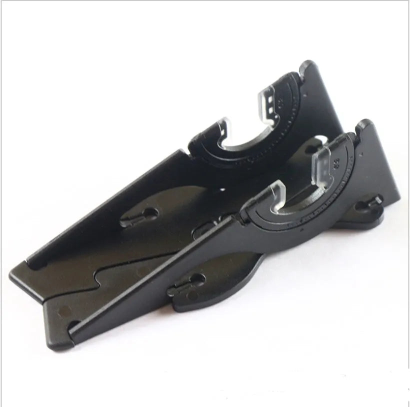 A black plastic card-shaped mobile phone holder on a desk, holding a smartphone at an angle.