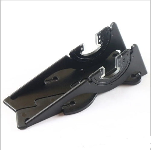 A black plastic card-shaped mobile phone holder on a desk, holding a smartphone at an angle.