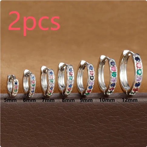 Set of gold, rose gold, and silver perforated circle stud earrings in multiple sizes on a flat surface.