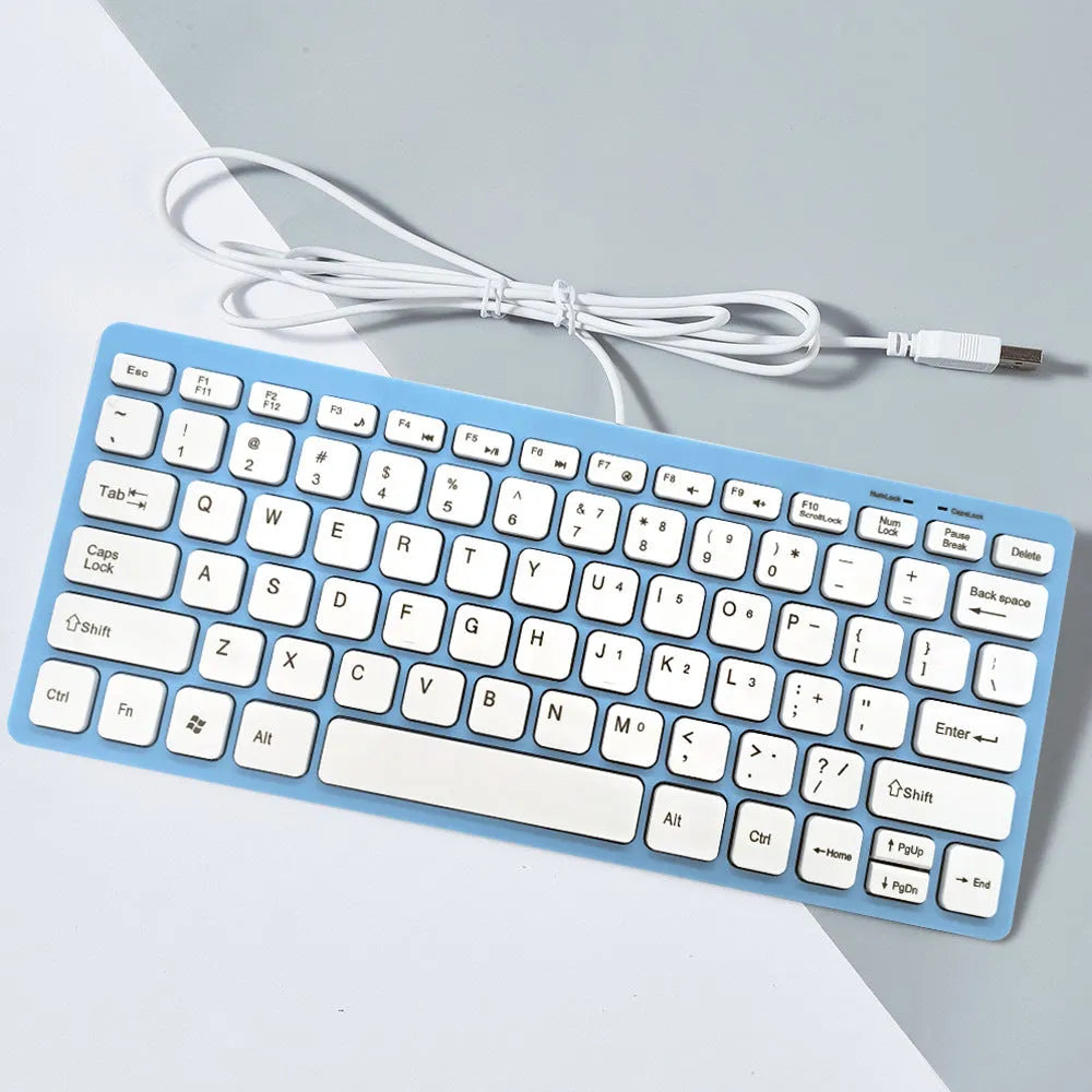 Compact USB wired mini keyboard in black, white, pink, or blue on a desk.