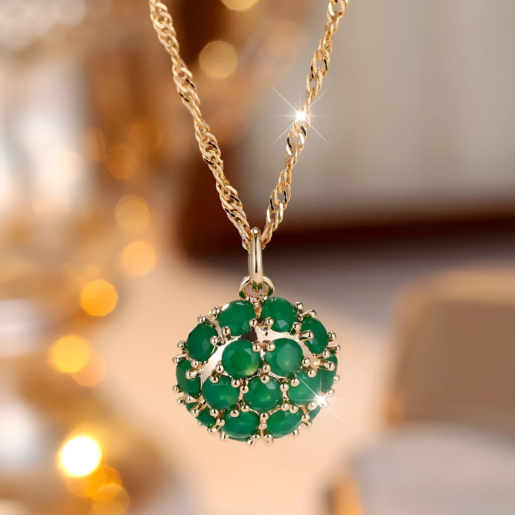 Geometric copper pendant necklace with round emerald and diamonds on an adjustable chain in champagne gold.