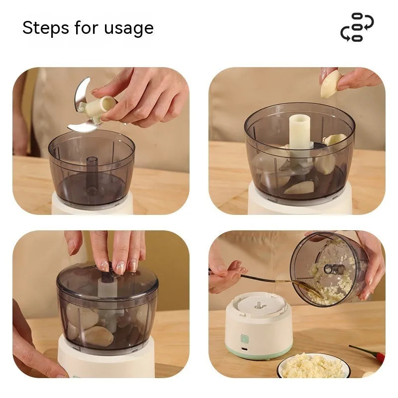 Mini electric food processor in light green with transparent cup and stainless steel blades on countertop.