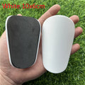 Extra small black and white plastic football shin guards for youth players, size 8cm by 5cm.