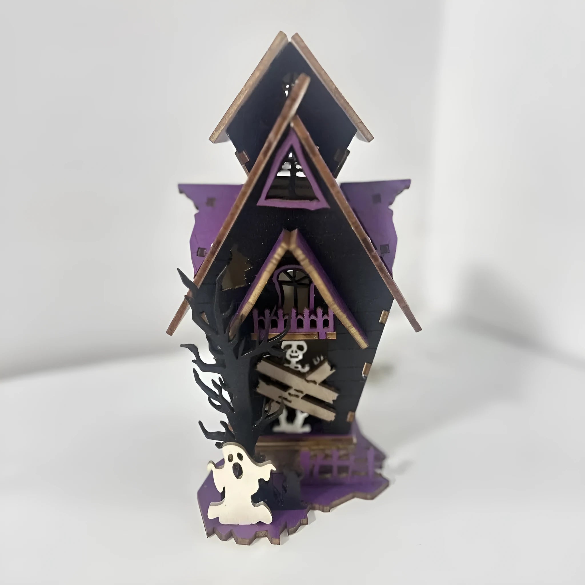 Wooden glowing haunted house Halloween table decoration on a dark surface