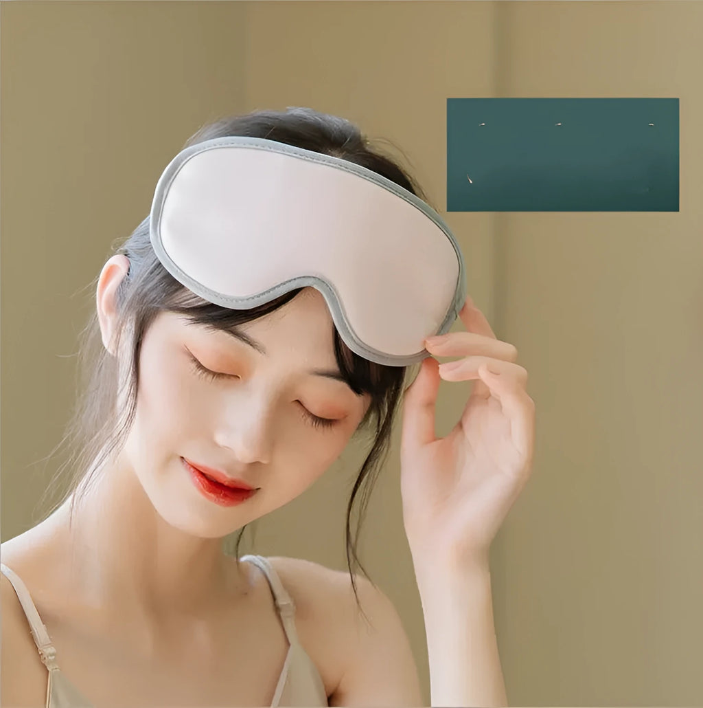 Green portable eye steam massage goggles with USB cable on a table.