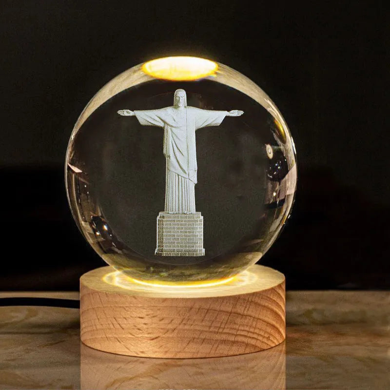 White crystal ball ornament on wood base with warm light and religious symbols
