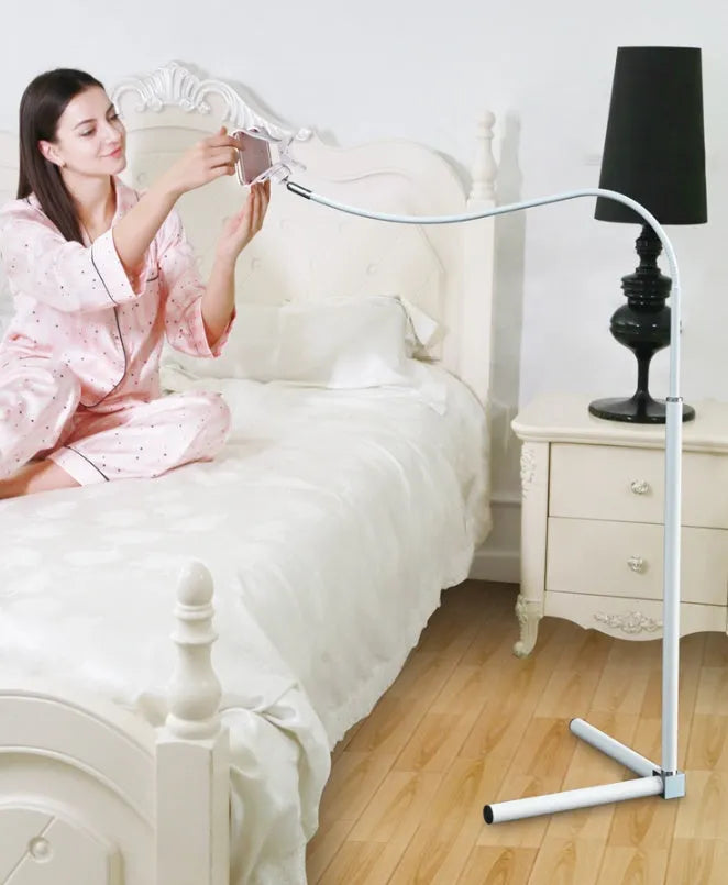 Black bedside mobile phone bracket with universal holder attached to bed frame for hands-free viewing