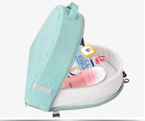 Portable foldable baby anti-mosquito isolation bed with grey cotton linen fabric, open on a grassy area
