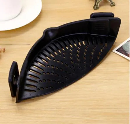 Silicone clip-on funnel strainer attached to a pot rim, showing hollow design and stainless steel buckle.