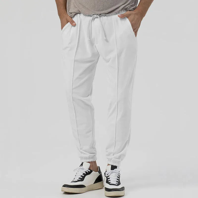 Men's grey loose tapered track sweatpants with elastic waist and straight leg design.