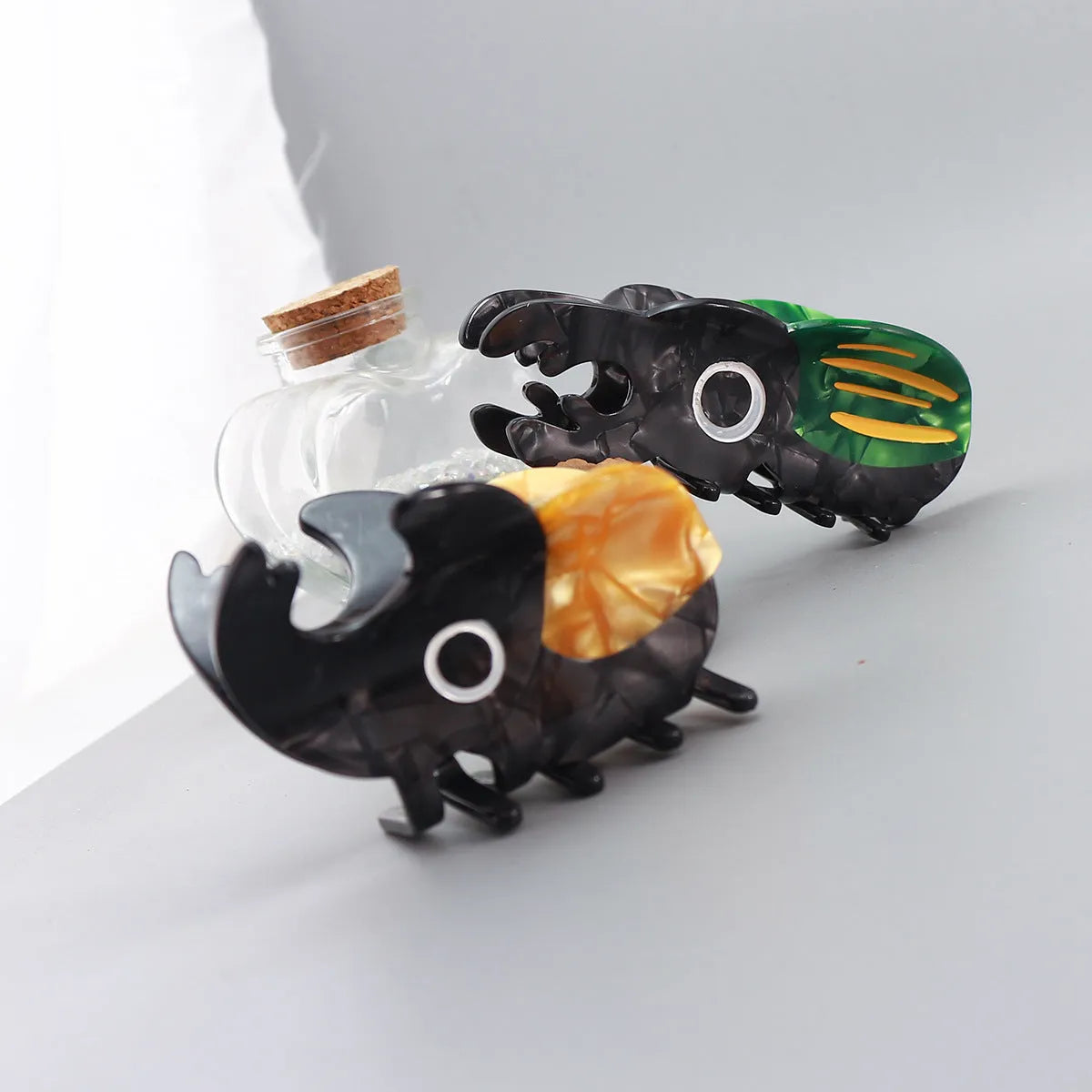 Handmade cellulose acetate insect grip with green beetle, orange beetle, and white caterpillar models for biology study.