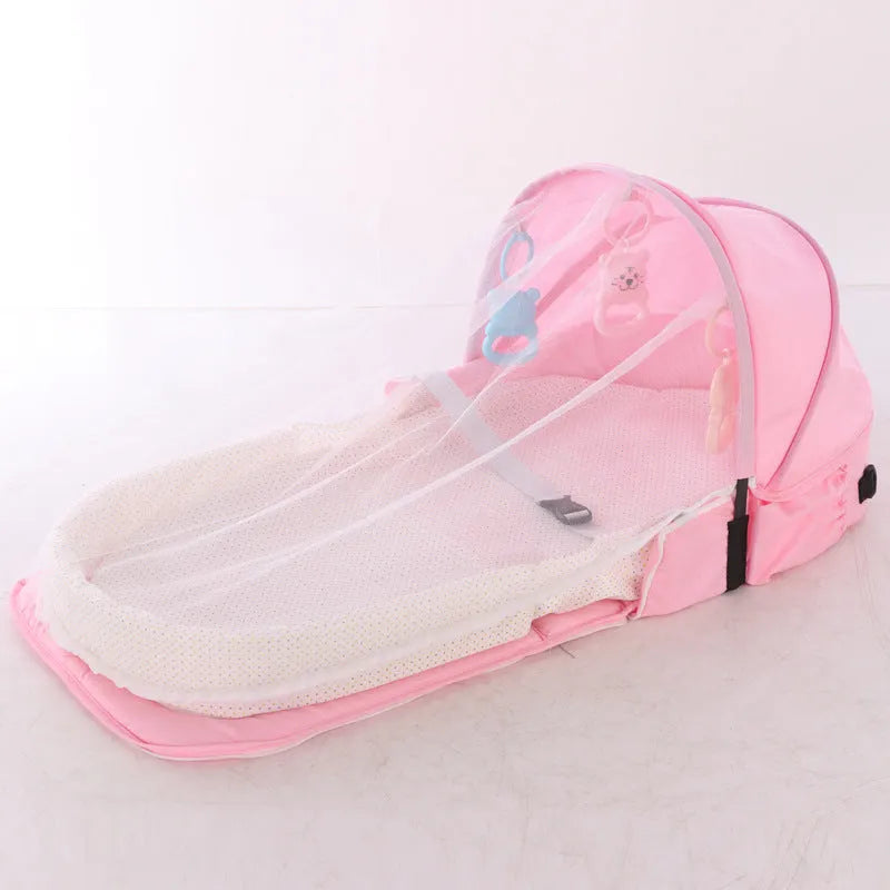Portable foldable baby anti-mosquito isolation bed with grey cotton linen fabric, open on a grassy area