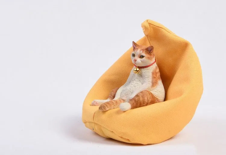Small lazy cat car ornament and sofa, 7.5cm tall resin model on a car dashboard.