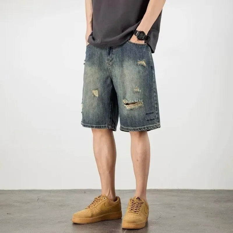 Blue retro-style men's denim shorts with a loose fit, distressed holes, and a straight-leg cut.