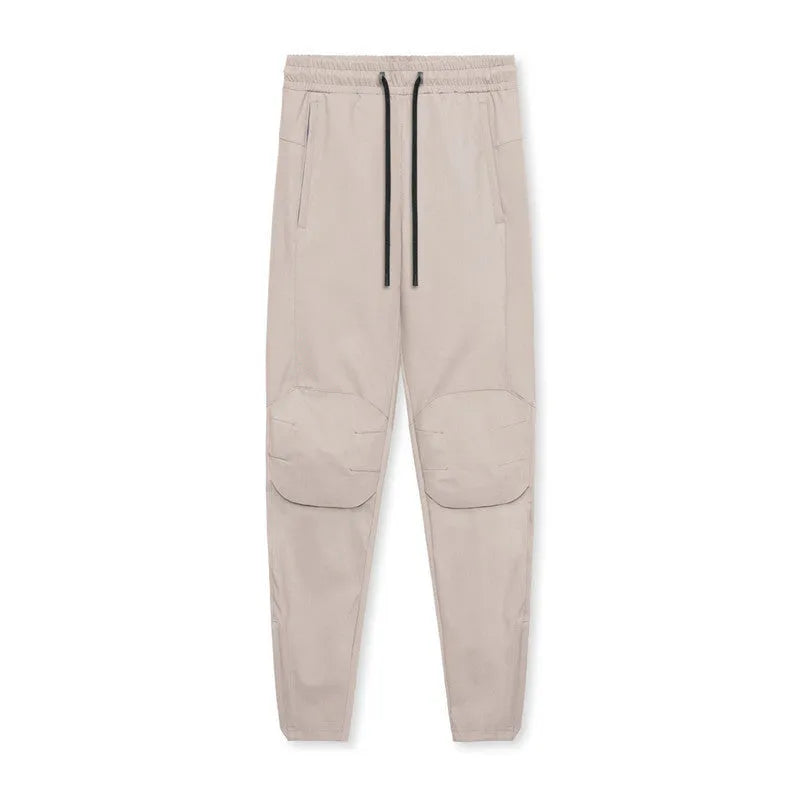 Men's grey loose-fit running pants with ankle ties on a gym floor