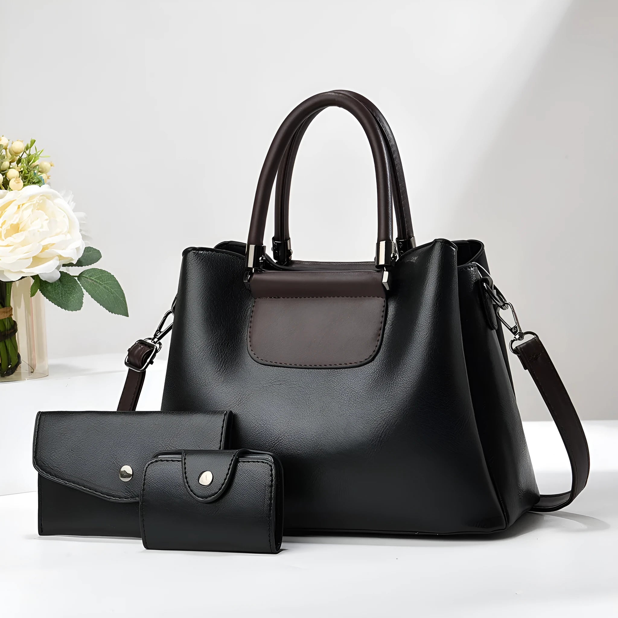 Large PU leather handbag set in horizontal square shape with matching medium and small pouches on white background