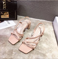 Women's white thick heel roman sandals with overshoot design on a flat background.