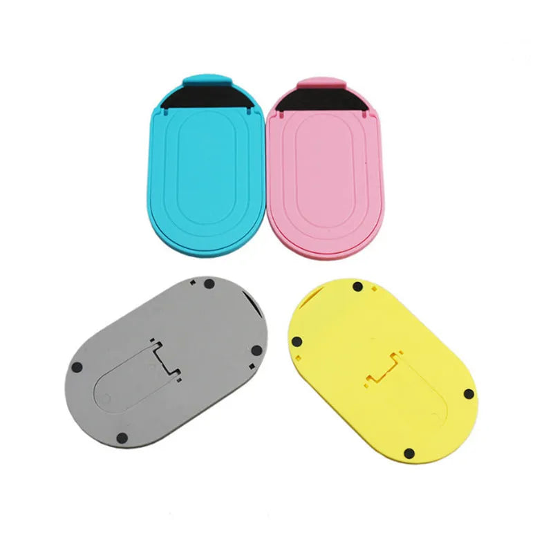 Plastic lazy bracket mobile phone stand shown in one of six available colours: black, blue, grey, pink, white, or yellow.