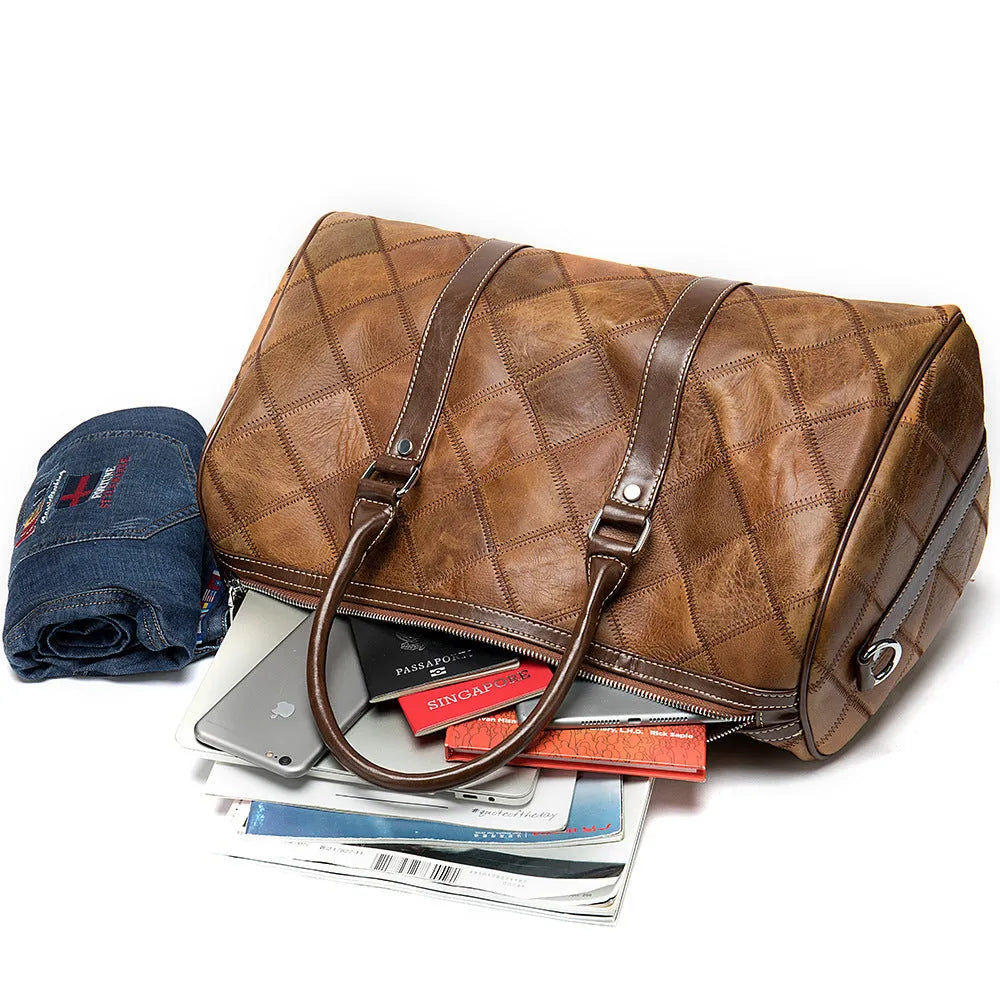 Vintage brown cowhide leather men's duffel bag with a single shoulder strap, shown open to reveal internal phone pocket and zippered compartment.