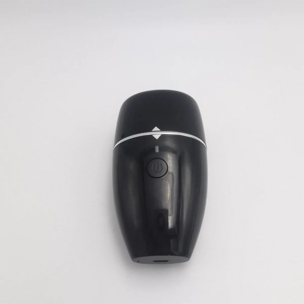 Black and white electric lip plumper device with USB charging cable on a plain background.
