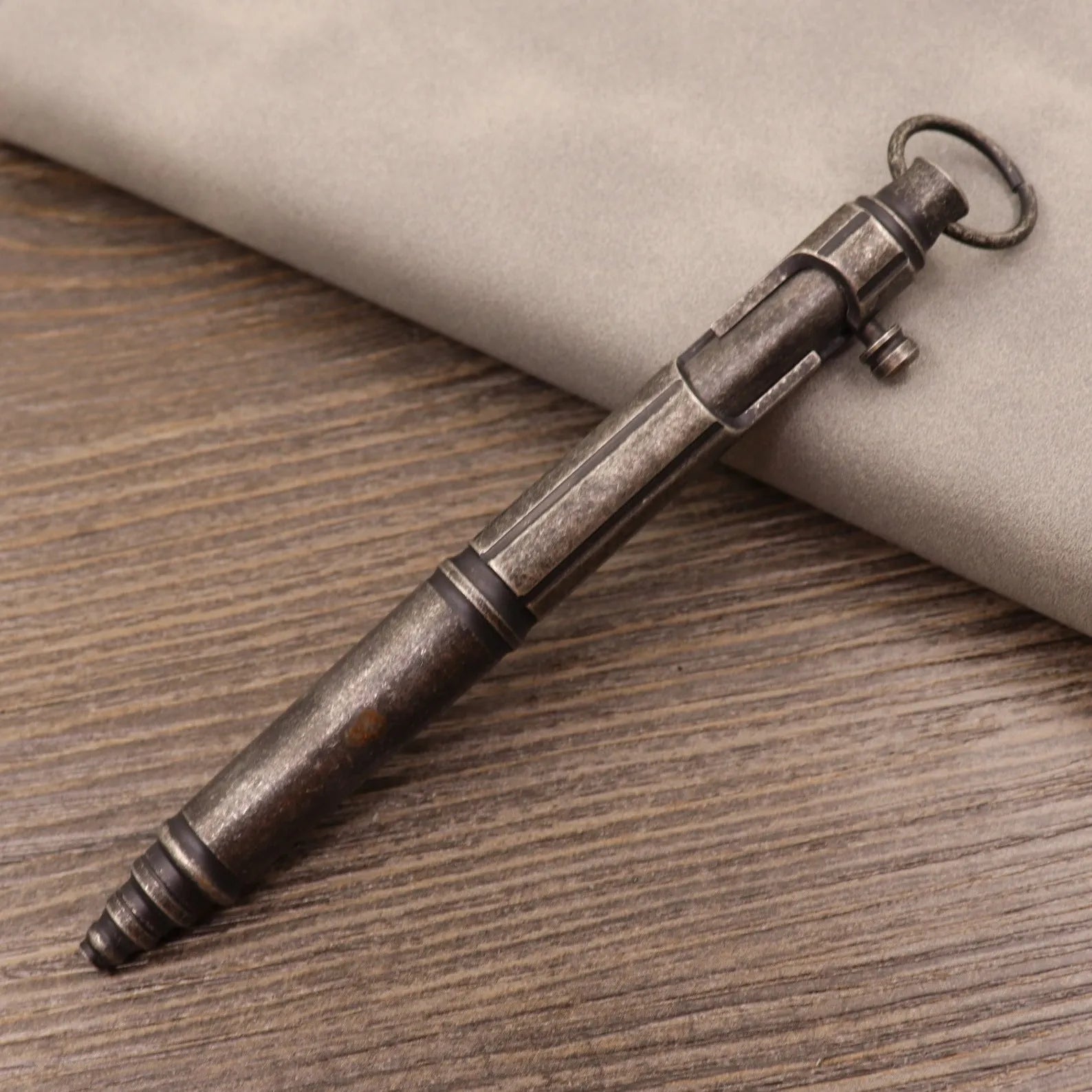 Retro brass tactical pen with cylindrical barrel and six-ring grip, shown with press mechanism extended