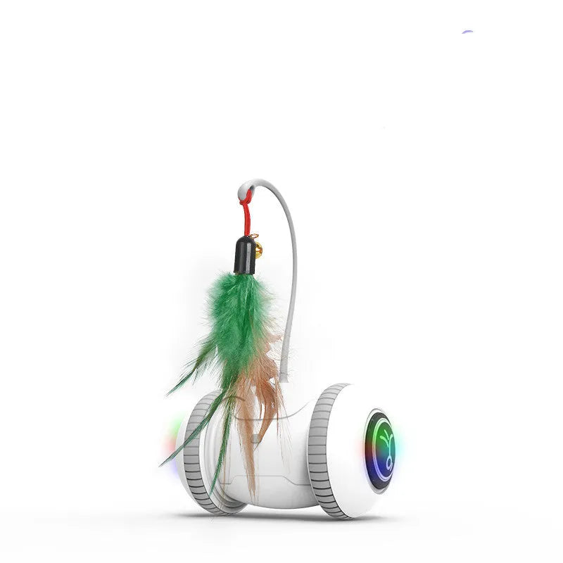 White and grey automatic interactive cat toy with interchangeable feather accessory on a floor, USB cable attached