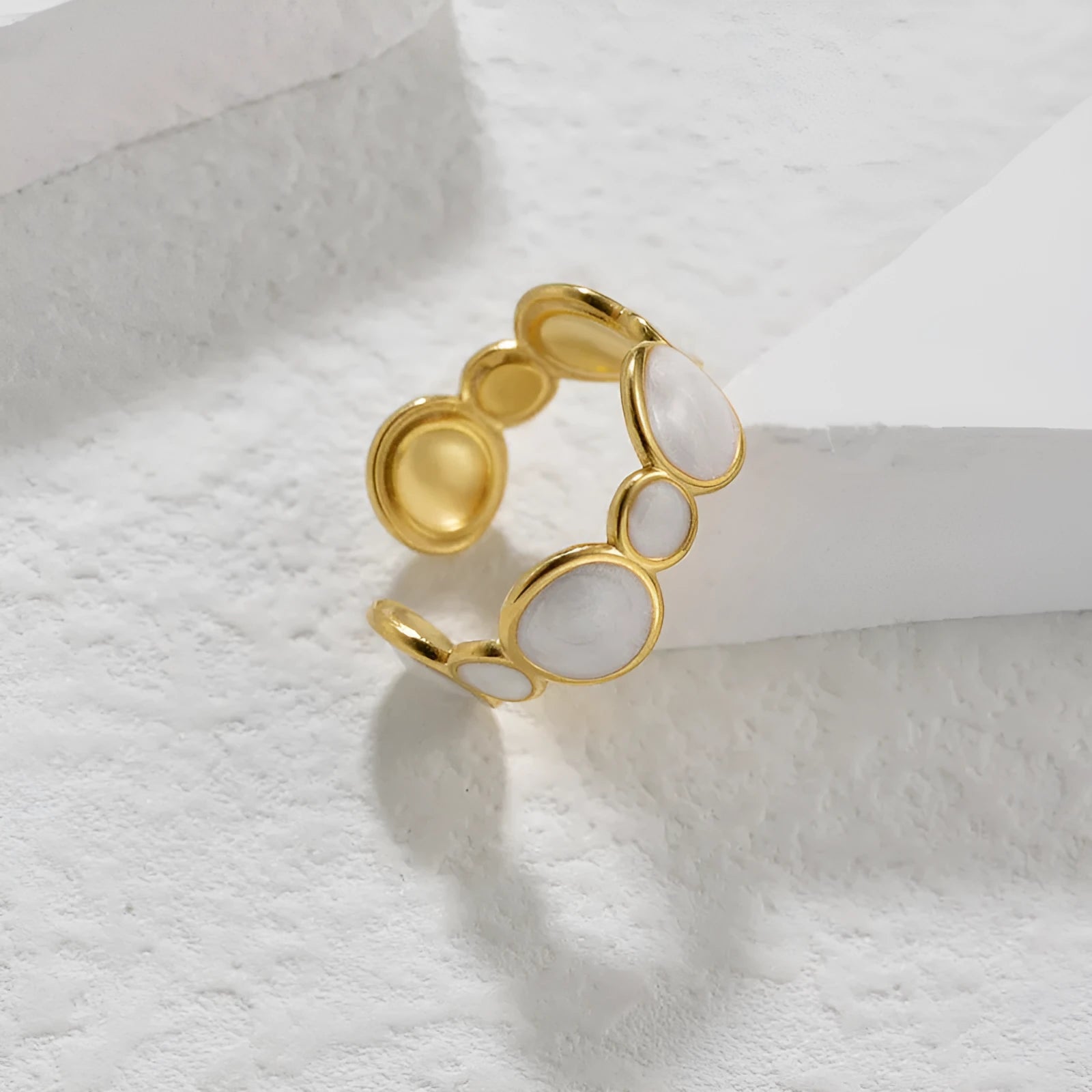 Women's silver geometric ring with an adjustable opening on a grey background.