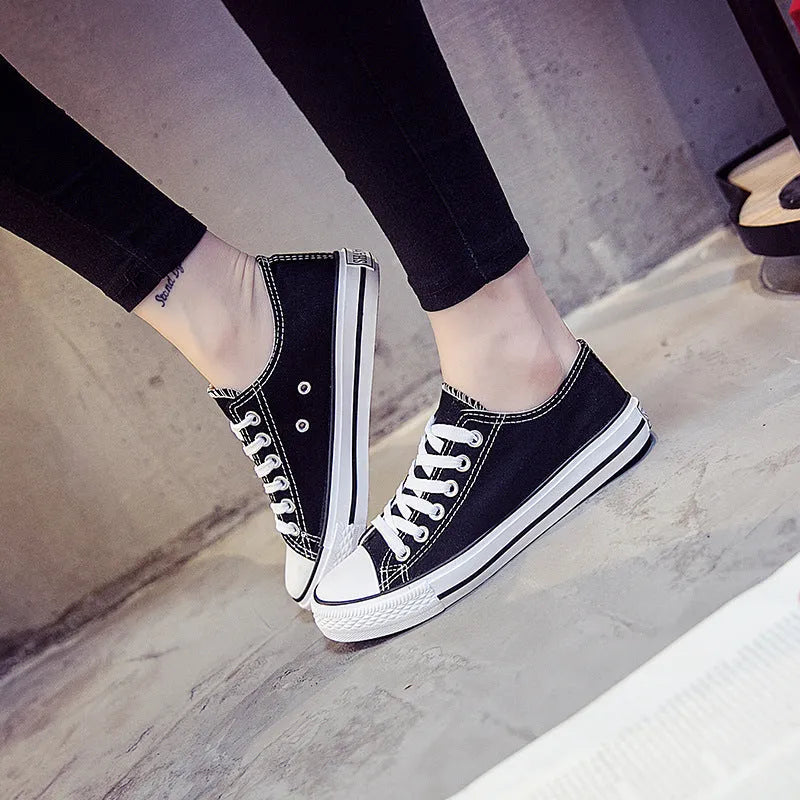 Solid colour women's canvas lace-up flats in black, shown on a white background.