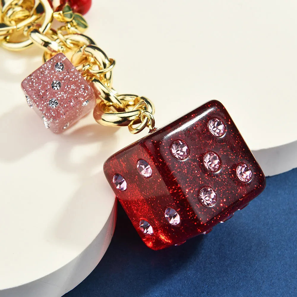 Vintage cherry two-tone square metal dice bag keychain pendant on a keyring.