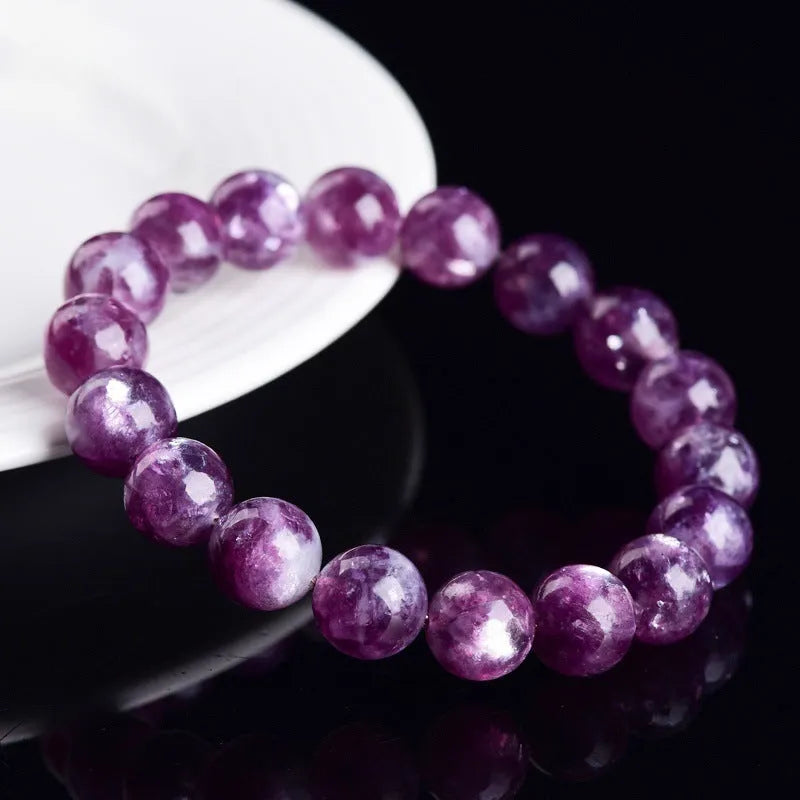 Purple polished crystal beaded bracelet with geometric beads on a white background.