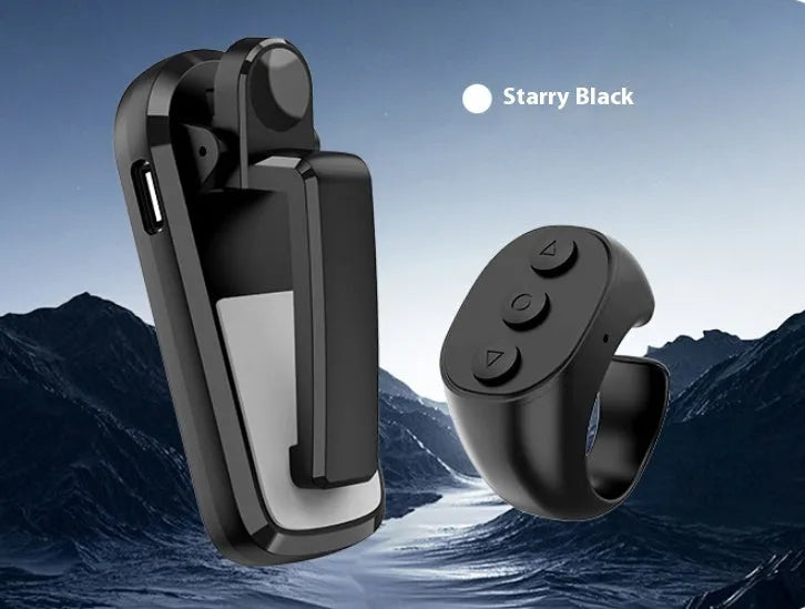 A black wireless page turner remote control and a separate clicker unit on a wooden desk.