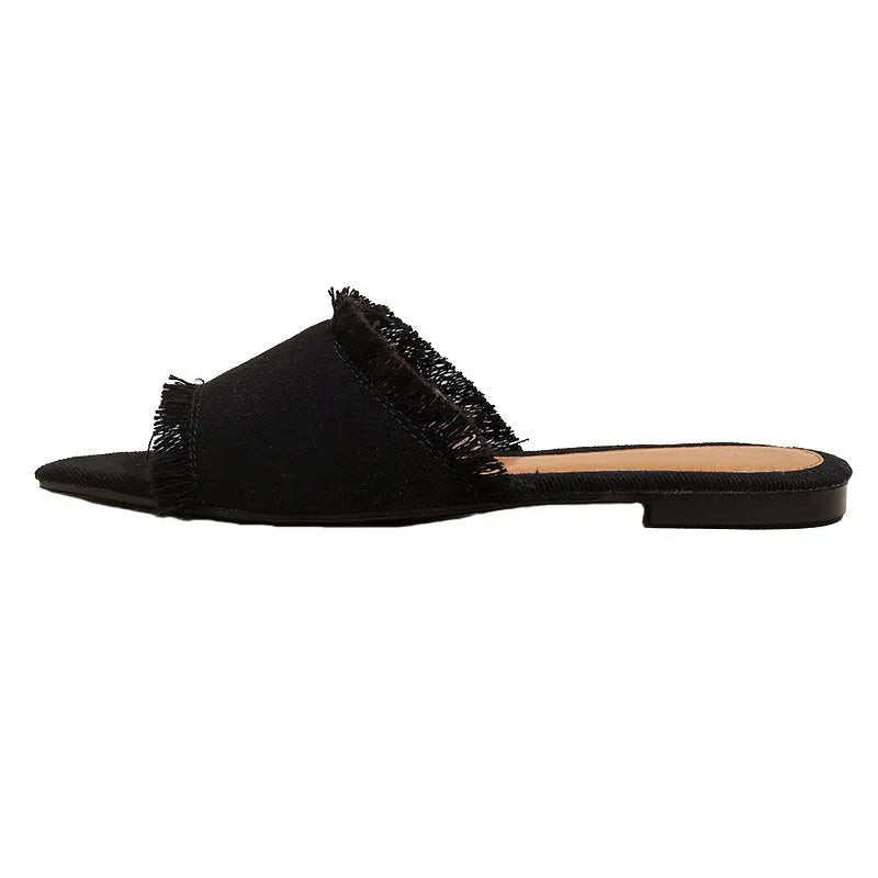 Solid colour denim women's slippers with a tassel detail, showing leather lining and PVC sole.