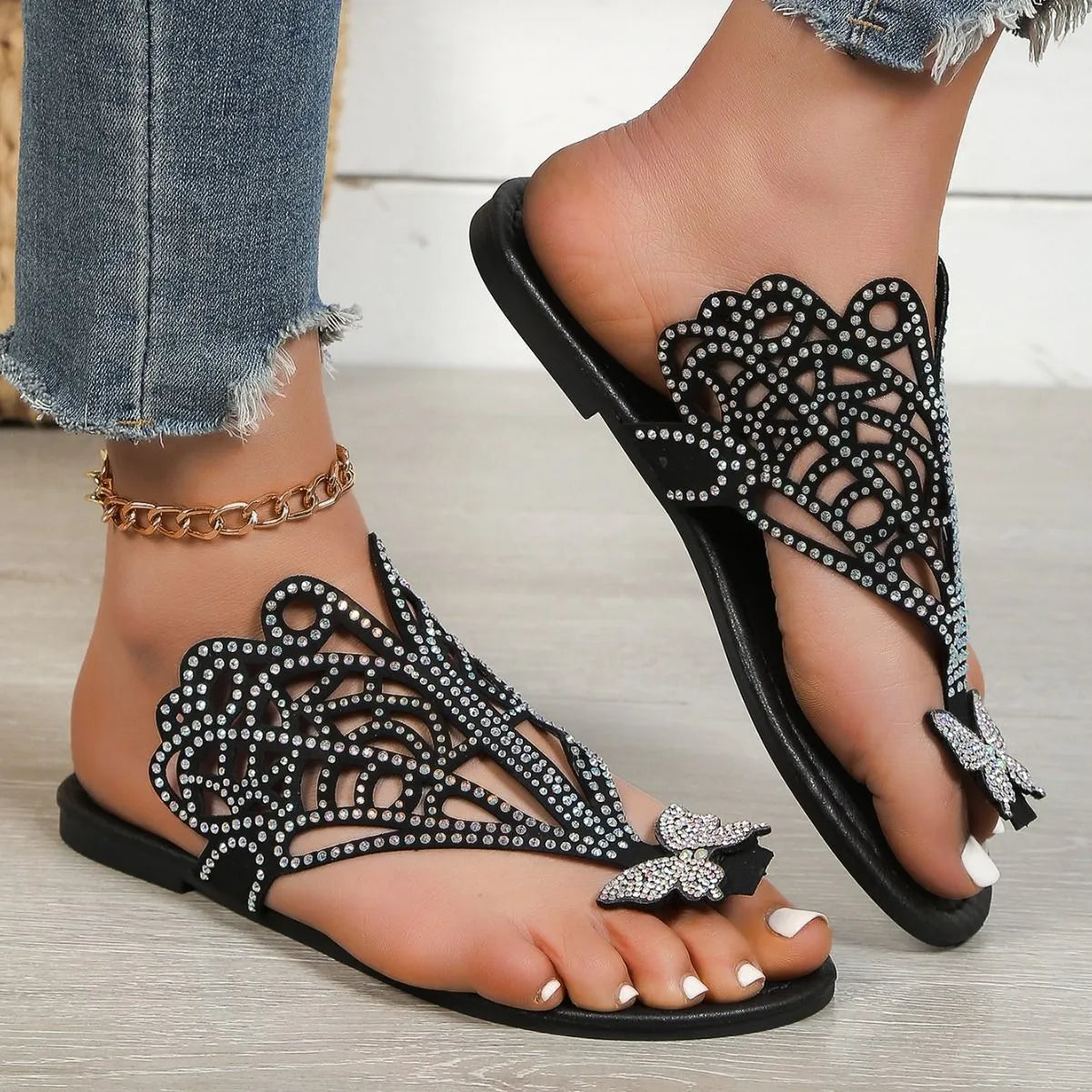 Women's black flip-toe sandals with rhinestone detailing and hollow design on flat rubber sole