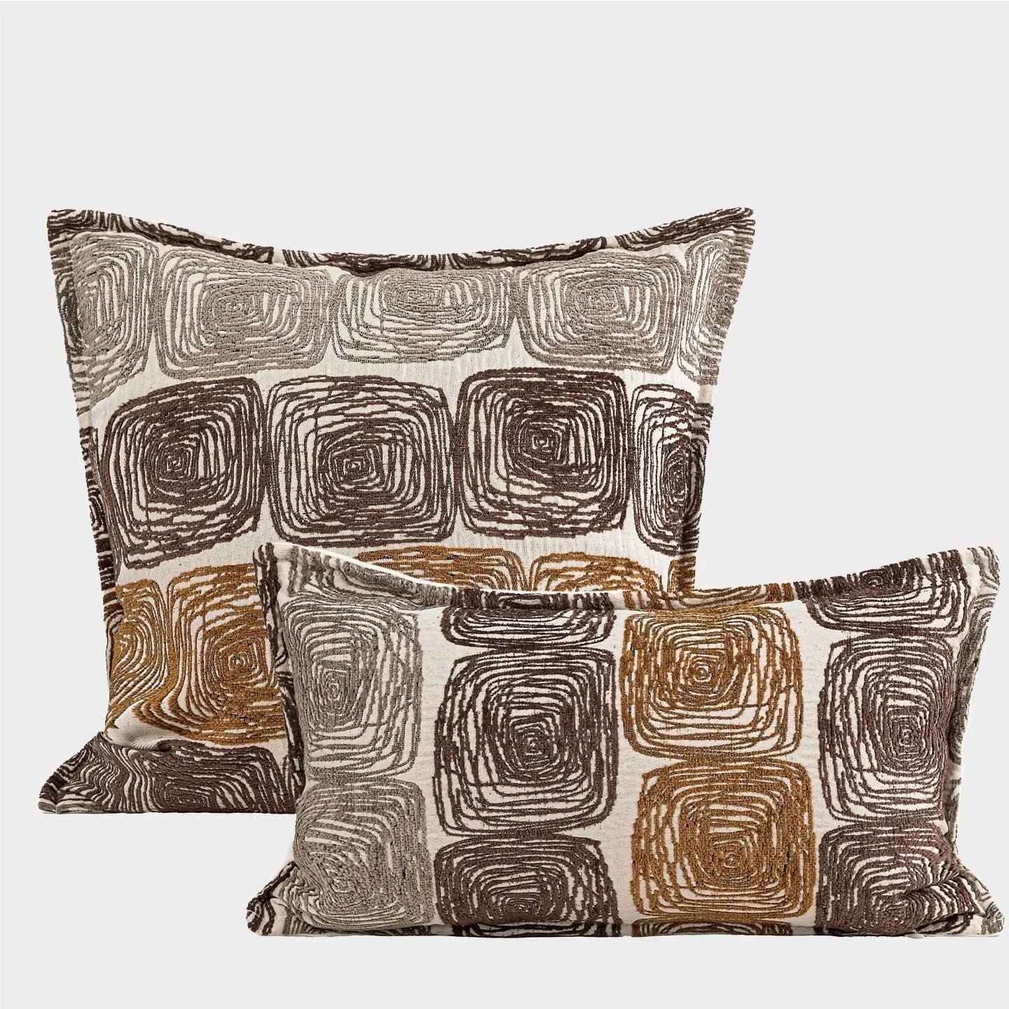 Cream and coffee abstract coil pattern pillow cover on a grey sofa