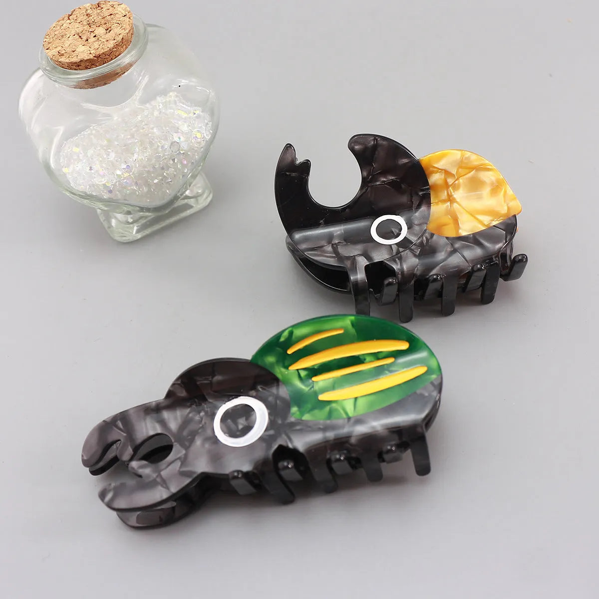 Handmade cellulose acetate insect grip with green beetle, orange beetle, and white caterpillar models for biology study.