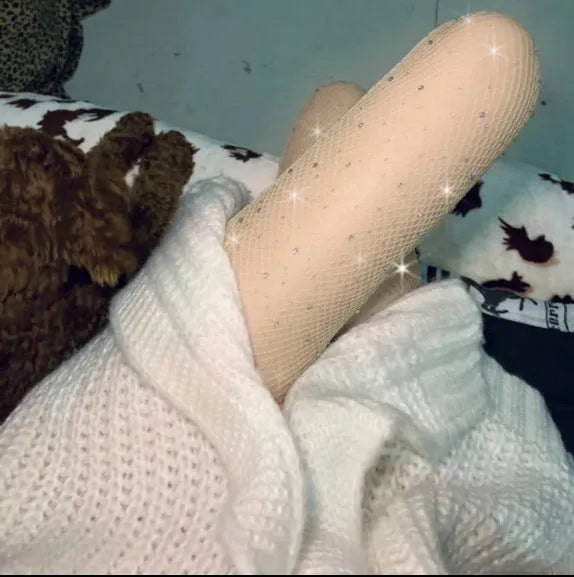 A pair of thin mesh fishnet stockings for women in solid skin colour, laid flat.