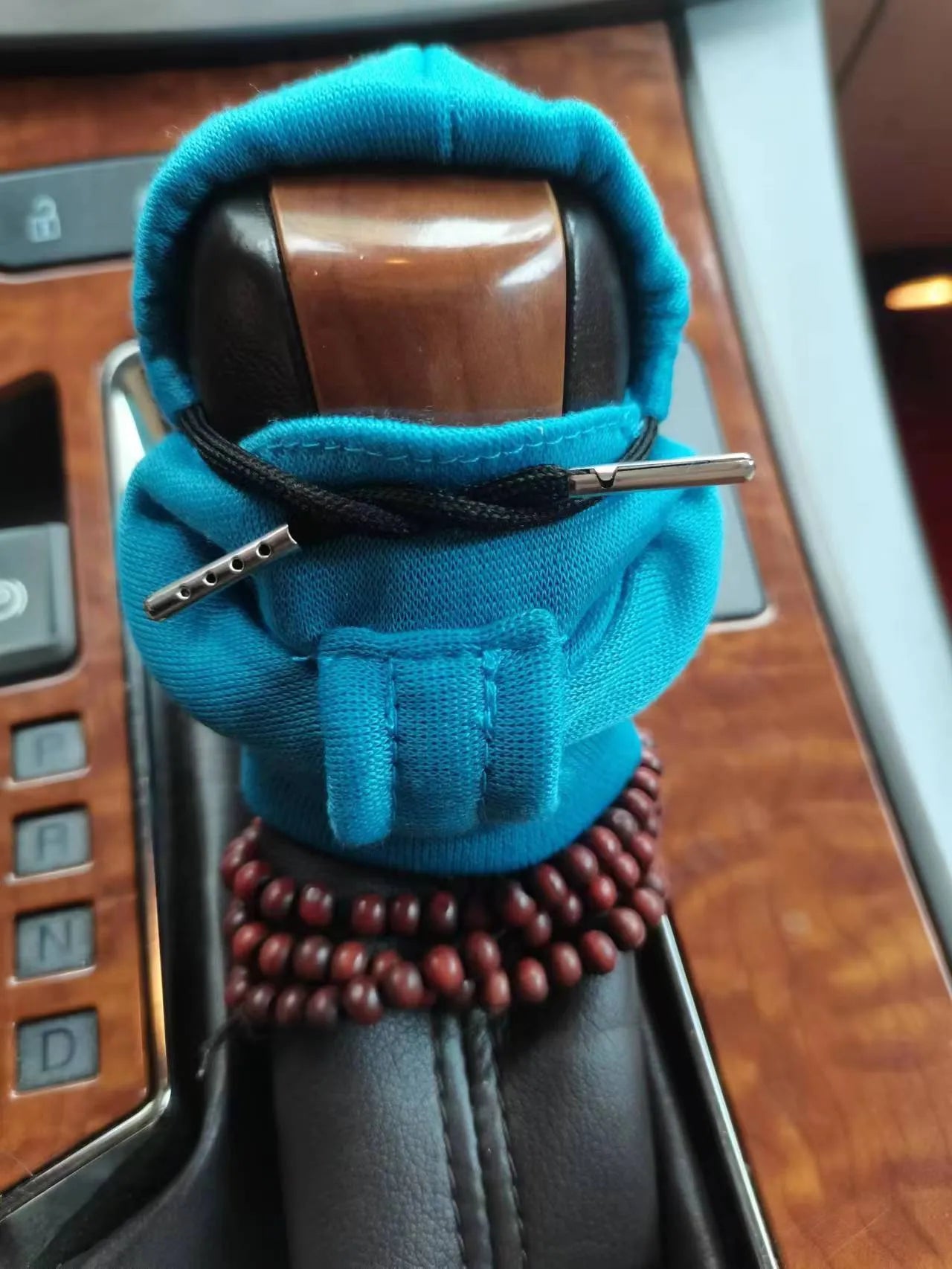 Dutch velvet car gear handle sleeve cover in multiple colours on a car gear lever.
