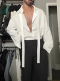 White oversized tie-front shirt with relaxed fit, open collar, and regular-length cut on a plain background