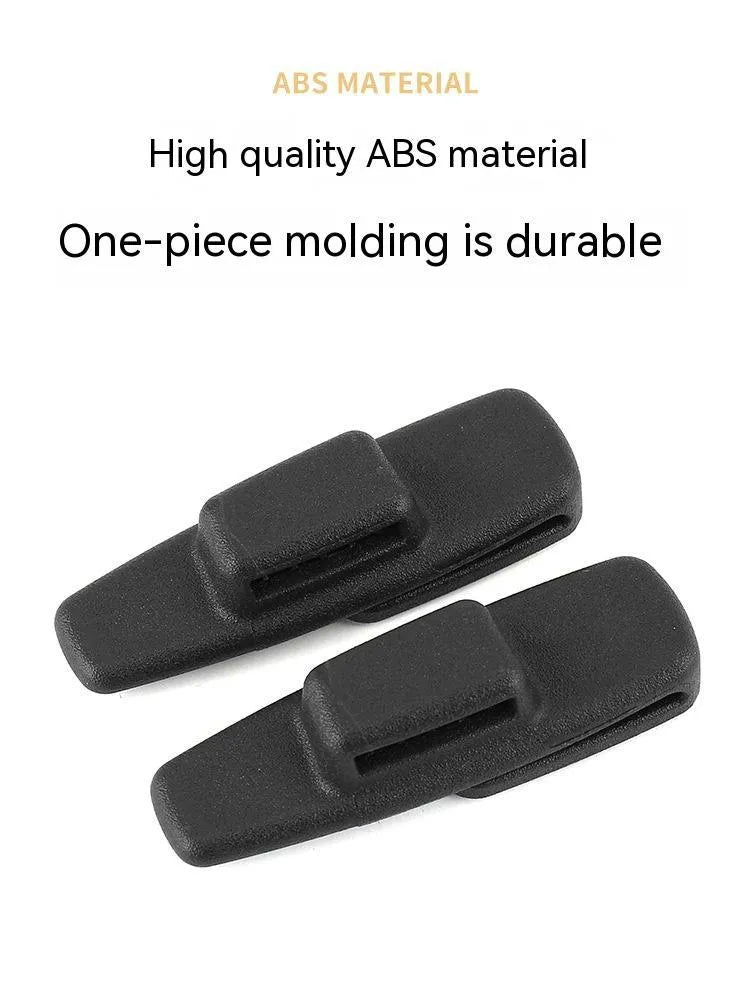 Two black ABS plastic car seat belt stopper clips on vehicle seat