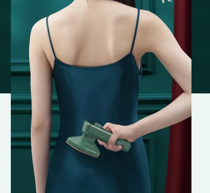 Dark green portable hanging steam iron with ceramic panel and power cord.
