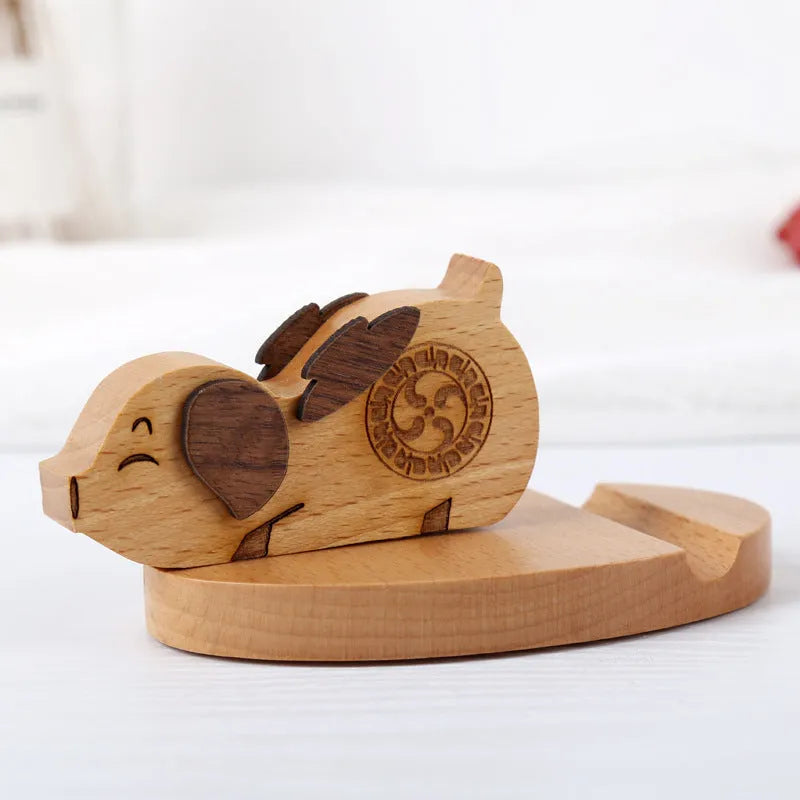 Beech wood mobile phone holder stand with coin slot and decorative carving.